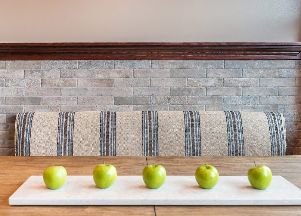 Dark wood molding over stone wall with built-in bench and wood table