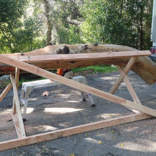 The log chosen off a beach to become the arched doorway to the structure laid out on a wood saw horse