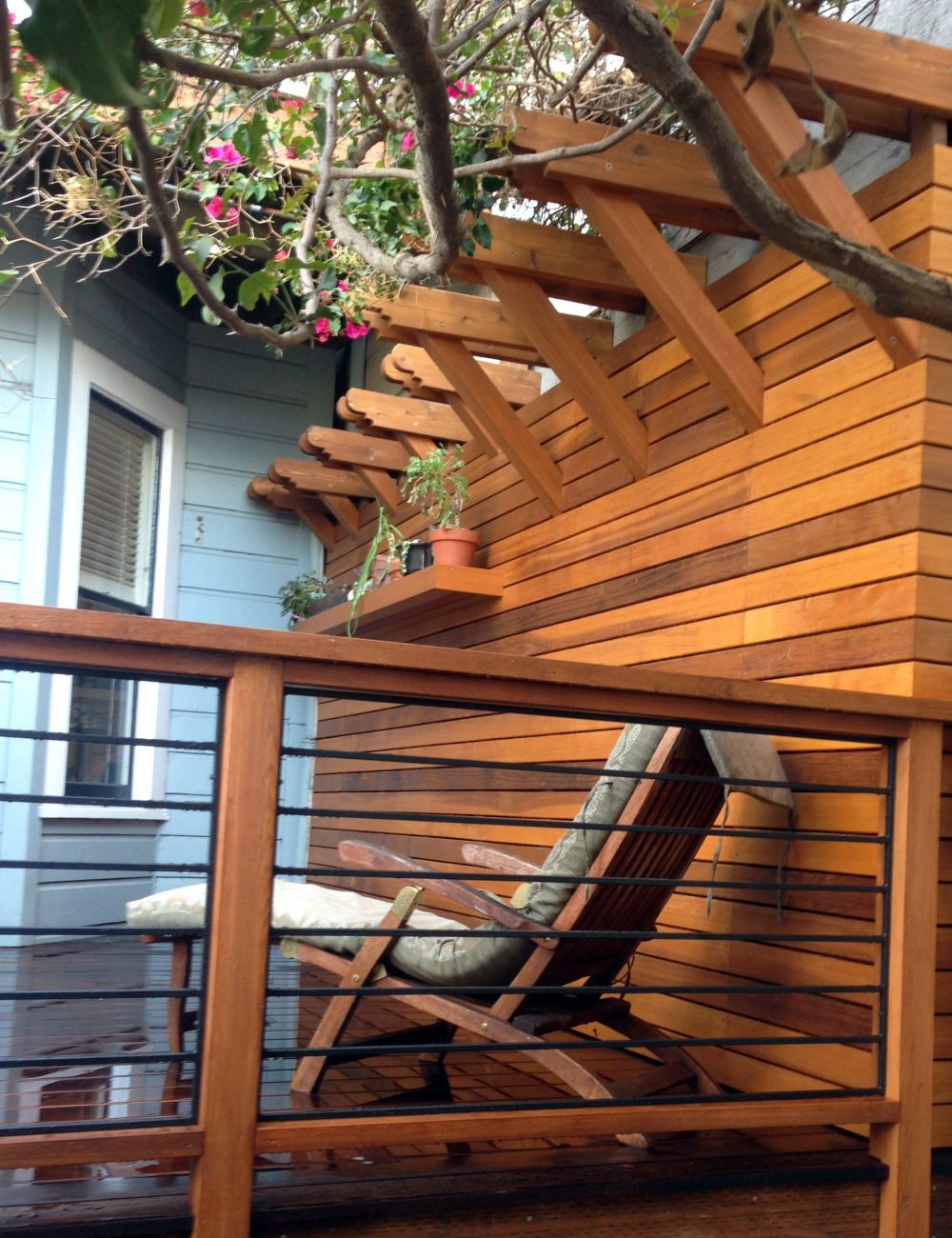 Wood and wire railing attached to same wood fencing with a flower awning