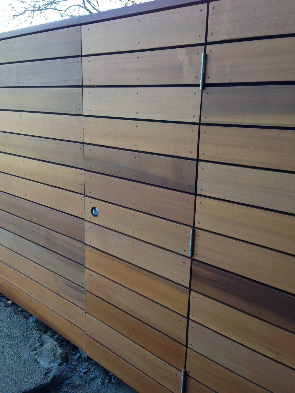 Multi-colored wood slat fence with hidden door