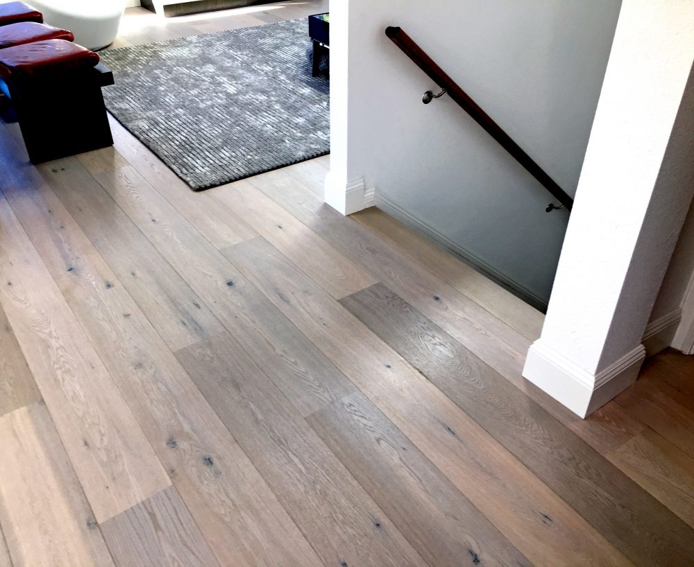 Wood floor installation upstairs and showing cut around top of stairs walls and moulding